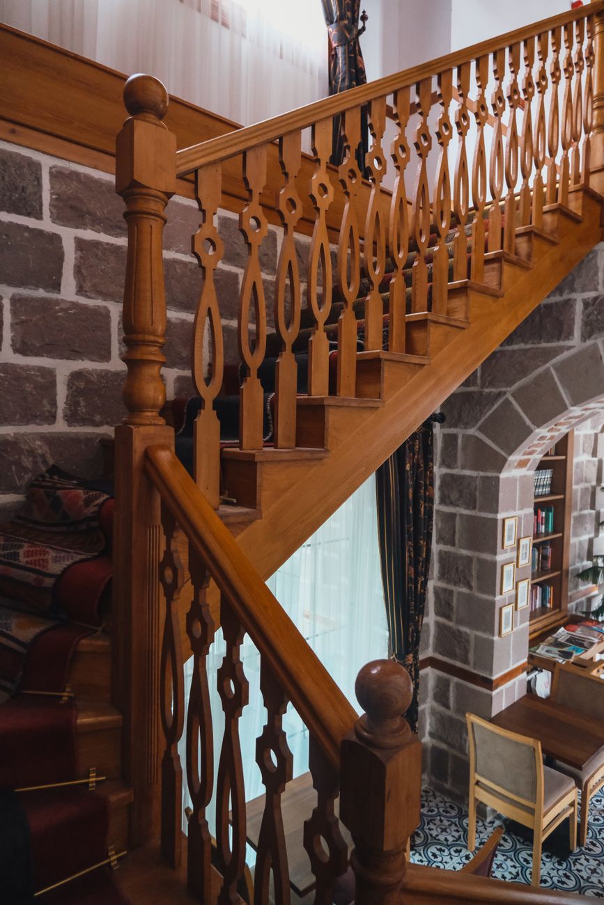Massivholztreppe mit gedrechselten Balustern und durchgehendem Handlauf in einem Wohnhaus.